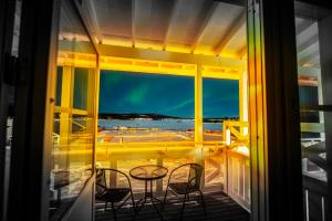 ÖverkalixGrand Arctic Resort的阳台配有桌椅,享有海景。