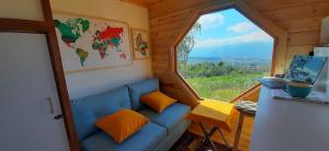巴里查拉Mini Casa Barichara的小房间设有蓝色的沙发和窗户
