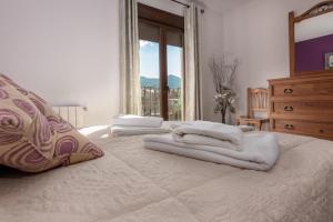 El OjueloMirador de El Yelmo的卧室配有带窗户的床上白色毛巾