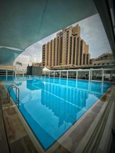 巴格达Babylon Rotana Hotel的一座游泳池,其背后是一座大型建筑