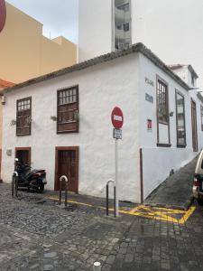 圣克鲁斯-德拉帕尔马Casa 1820 by Rural La Palma的一座白色的建筑,前面停有一辆摩托车
