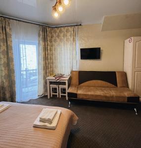 布克维Viktan Hotel的一间卧室配有两张床、一张桌子和一台电视。