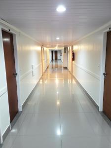 巴拉曼萨Ano Bom Palace Hotel的白色地板和天花板的建筑里空无一人的走廊