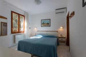 普罗基奥瓦莱维德酒店的一间卧室设有蓝色的床和窗户。