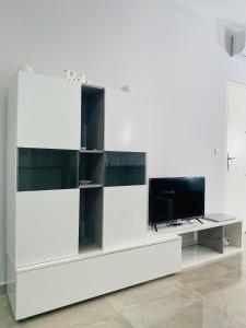 福恩吉罗拉Luxury Suite Fuengirola 1的带平面电视的白色娱乐中心
