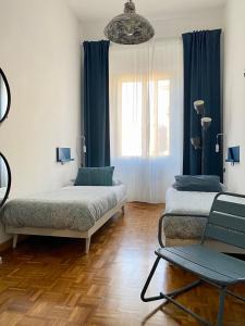 佛罗伦萨B&B Monteverdi L'Arancio的一间设有两张床和椅子的房间
