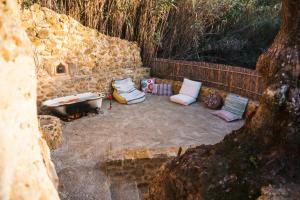 埃里塞拉EcoNature Dagaio Handmade Paradise的一组枕头坐在石墙旁边