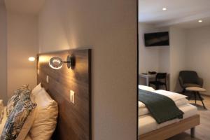 乐罗西奥伯格普雷沃克斯酒店的通往卧室的门,卧室配有一张床和镜子