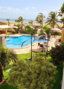 阿奎拉兹Atlantic Palace Family inn的享有棕榈树游泳池和大海的景色