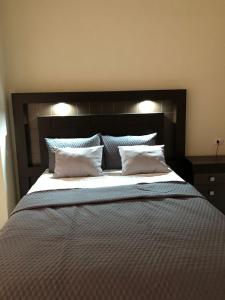 圣萨尔瓦多Hotel Finca San Nicolas的一张大床,配有黑色床头板和白色枕头