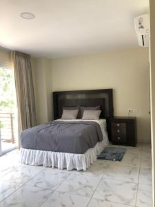 圣萨尔瓦多Hotel Finca San Nicolas的一间铺有大理石地板的卧室,配有一张大床