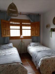 布维翁Casa La Pizarra的带2扇窗户的客房内的2张床