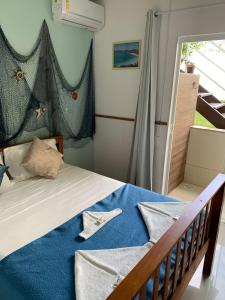 阿拉亚尔-杜卡布Americano's Suítes的一间卧室配有一张带蓝色床单的床和一扇窗户。