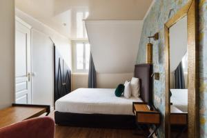 巴黎莫里斯格兰德大道酒店的一间卧室配有一张床和镜子