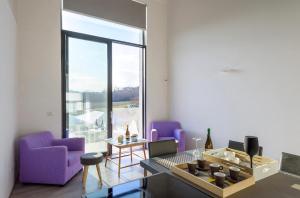 Abbadia a IsolaLoft a Montepulciano sopra Birrificio artigianale的客厅配有紫色家具和大窗户