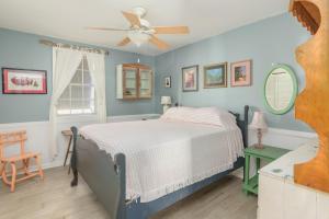 泰比岛My Tybee Queen的一间卧室配有一张床和吊扇