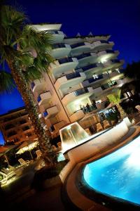 圣贝内代托-德尔特龙托奥特雷马雷住宅酒店的一座大型建筑,旁边设有游泳池