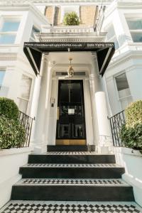 伦敦Merit Kensington Hotel的白色的房子,设有通往门的楼梯