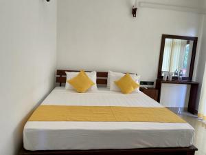 阿努拉德普勒Theon Resort的一间卧室配有一张带黄色枕头的大床