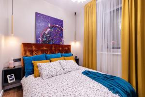 维尔纽斯Lovely apartment Traku str.的一间卧室配有蓝色和黄色窗帘的床