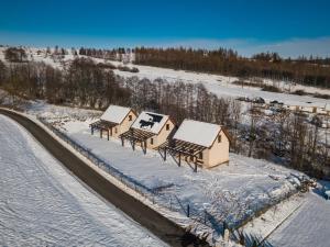 格武希察Domki W Zaciszu Gomólnika的雪中一组小屋的顶部景色