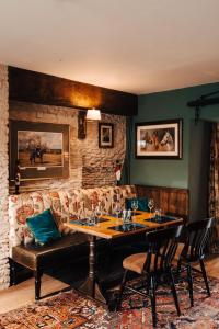 Shipton MoyneCat and Custard Pot Inn的一间带桌子和沙发的用餐室