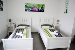 梅肯博伊伦Ferienwohnung am Seewald的配有白色床的小客房内的两张床