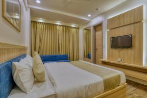 博帕尔Hotel Centre Park Bhopal的一间卧室配有一张大床和电视