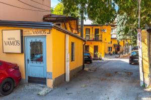 萨拉热窝Hotel Vamos Sarajevo, b&b的一条街上有蓝色门的黄色建筑