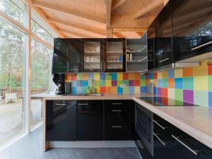 诺格Idyllically located Holiday Home in Norg with Sauna的厨房配有黑色橱柜和彩色的墙壁瓷砖