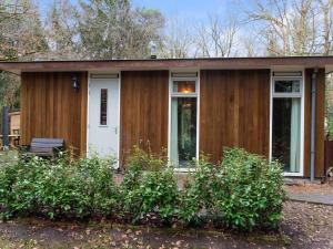 诺格Idyllically located Holiday Home in Norg with Sauna的一间小型木屋,设有白色的门和窗户