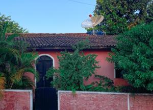 伦索伊斯Pousada Aconchego - Suítes Rústicas e Privativas的一间红色的房子,上面有一颗卫星天线