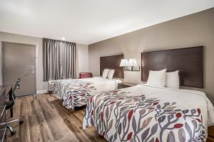 萨姆特Red Roof Inn Sumter的酒店客房配有两张床和一张书桌