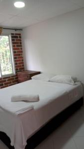 伊瓦格Apartamento Amoblado en Ibagué的卧室配有白色的床和2条毛巾