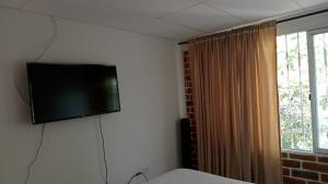 伊瓦格Apartamento Amoblado en Ibagué的卧室墙上的平面电视