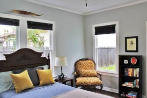 圣安东尼奥CasaMagnolia - Cheerful 3-bdrm home, free parking, 30 days or more的一间卧室配有一张床、一把椅子和窗户。