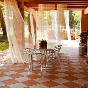 Settimo RottaroCameloth B&B的铺有瓷砖地板,设有带桌椅的庭院。