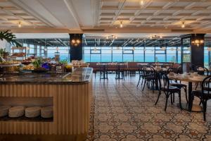 哈德拉Resort Hadera by Jacob Hotels的餐厅设有酒吧和桌椅