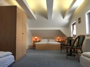 纳霍德Vyhlídka Resort的卧室配有一张床和一张桌子及椅子