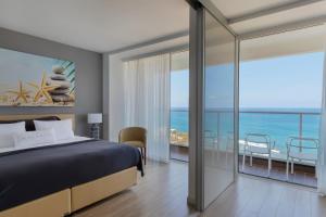 哈德拉Resort Hadera by Jacob Hotels的一间卧室配有一张床,享有海景