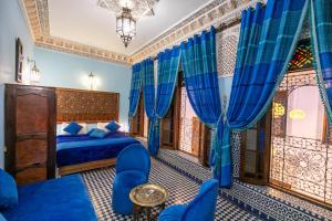非斯菲斯达尔特雷索酒店的一间卧室配有蓝色的床和蓝色窗帘