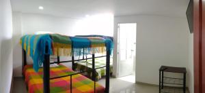 TocancipáCórest Hotel B&B的一间卧室配有一张双层床和色彩缤纷的毯子