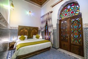 非斯菲斯达尔特雷索酒店的一间卧室设有一张床和一个彩色玻璃窗