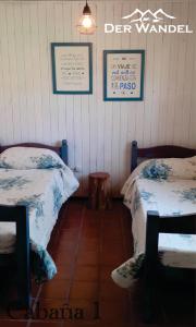 贝尔格拉诺将军镇Der Wandel的一间卧室配有两张床和一张桌子