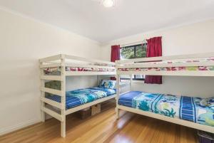 卡尔斯Phillip Island Time - Large home with self-contained apartment sleeps 11的客房设有两张双层床和一扇窗户。