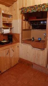 AlaskaCabaña Doña dacia的一个带木制橱柜和窗户的小厨房
