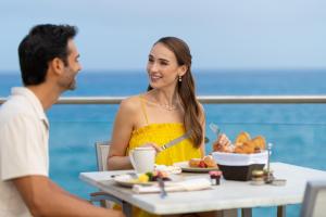 科苏梅尔科苏梅尔宫全包酒店的坐在餐桌上吃一盘食物的男人和女人