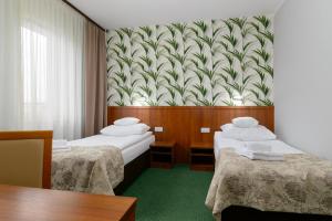 波兹南泽罗尼酒店的酒店客房带两张床和壁纸