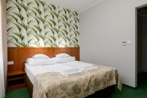 波兹南泽罗尼酒店的一间卧室配有一张带白色毛巾的床
