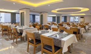 阿拉尼亚莫纳尔特城市酒店 - 全包的一间设有白色桌椅的用餐室